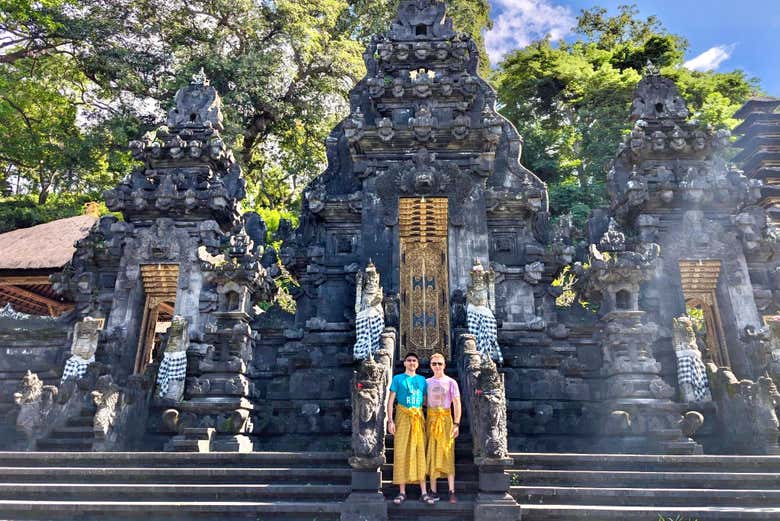 In posa con il tempio Goa Lawah sullo sfondo