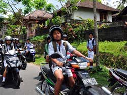 Bambini che guidano delle moto a Bali