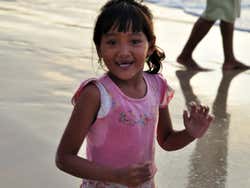 Bambina sulla spiaggia di Jimbaran al tramonto